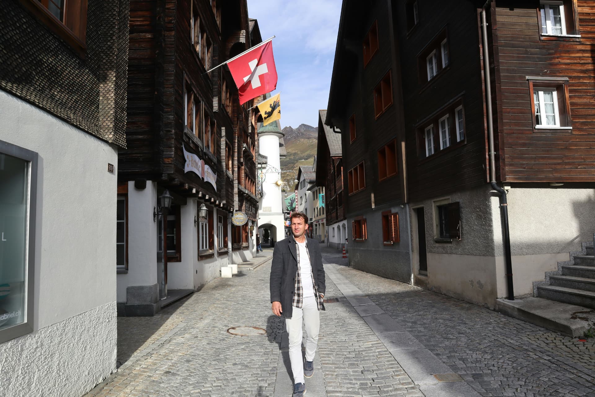 Marco, l'investisseur suisse derrière Le Smart Investisseur, se promenant dans une rue de village alpin